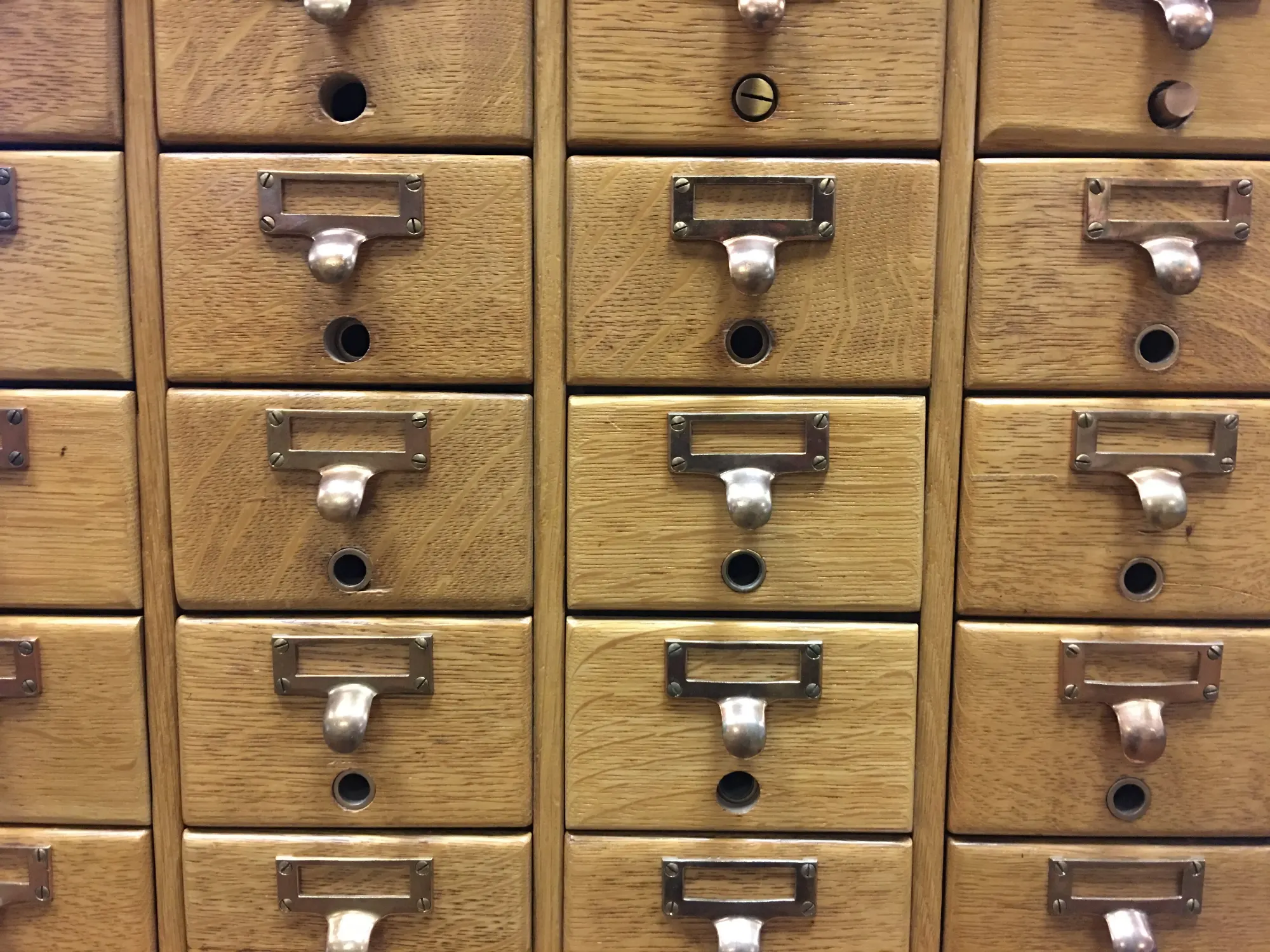 Wooden card catalogue drawers with brass pulls and label holders