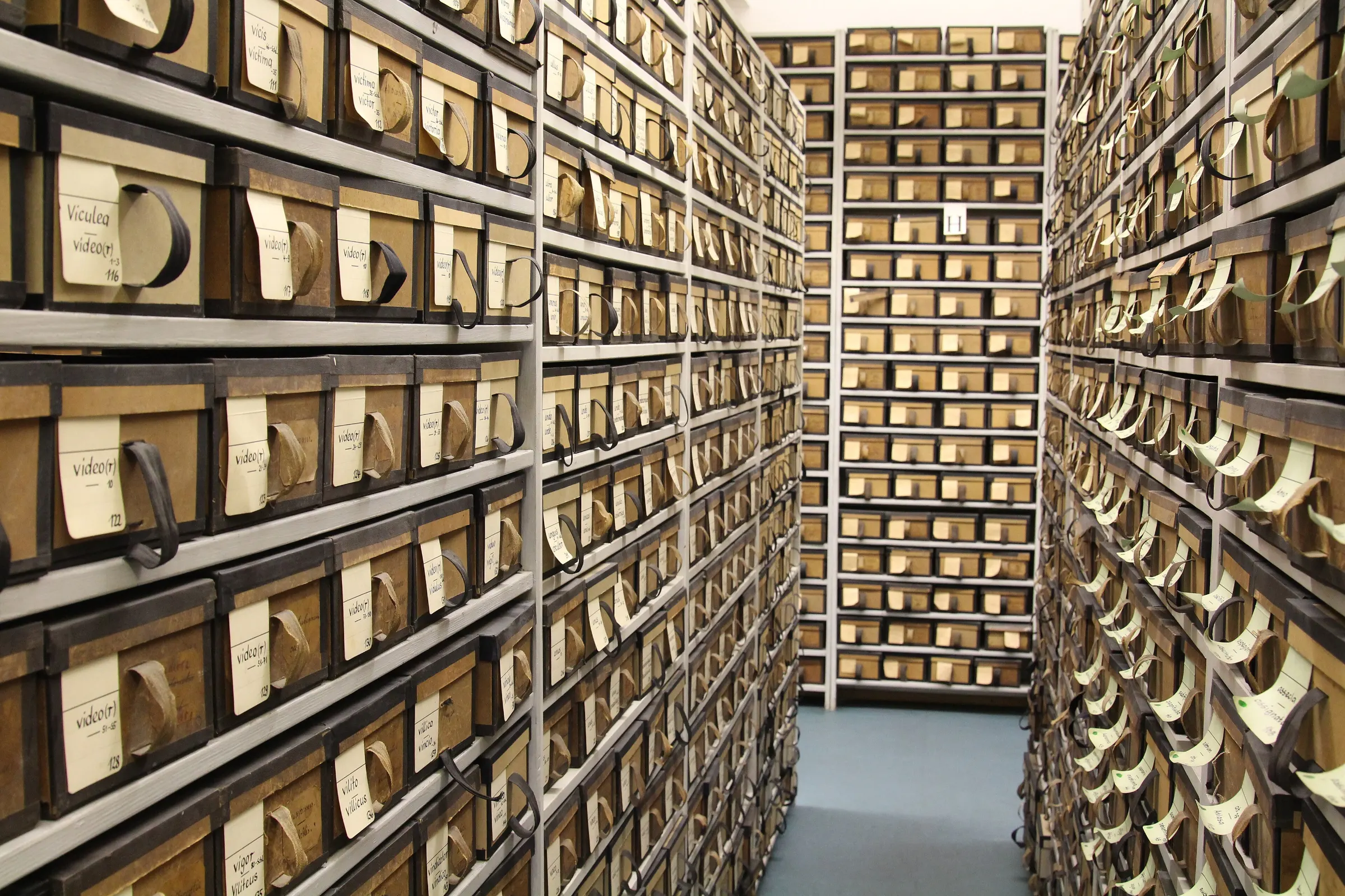 An aisle between shelves filled from floor to ceiling with labelled slip boxes